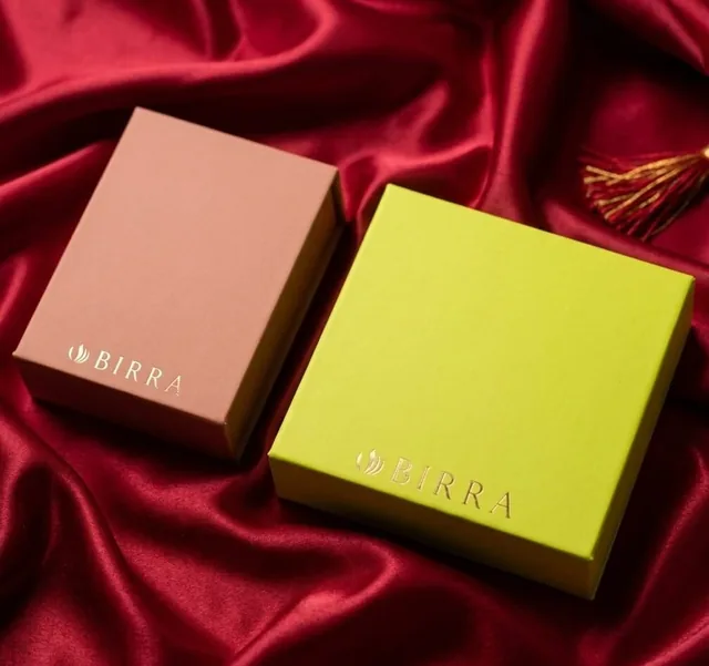 Two-tone rigid attar boxes for Birra on burgundy satin