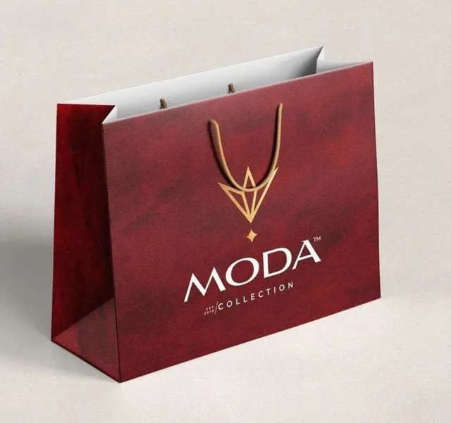 Deep red paper bag with gold emblem and cord handles