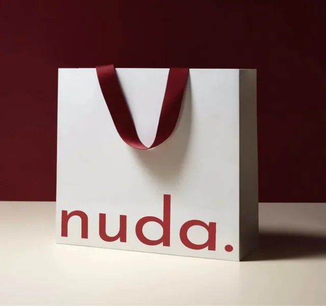 White paper bag with red satin ribbon handles