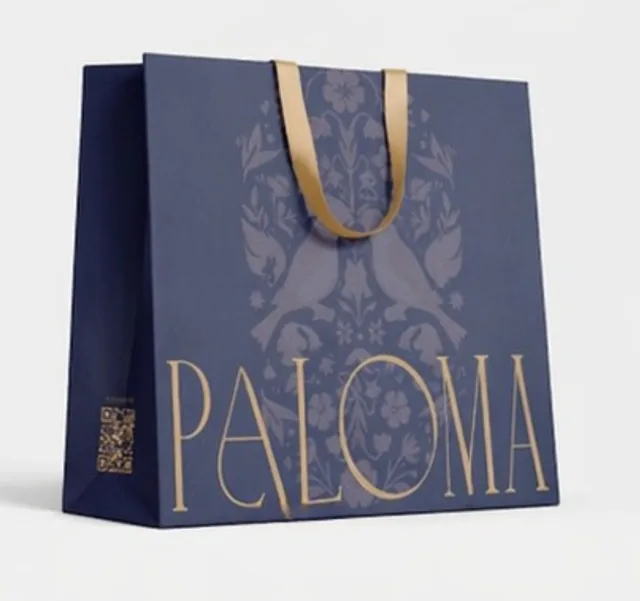 Navy paper bag with tonal bird pattern and gold Paloma lettering