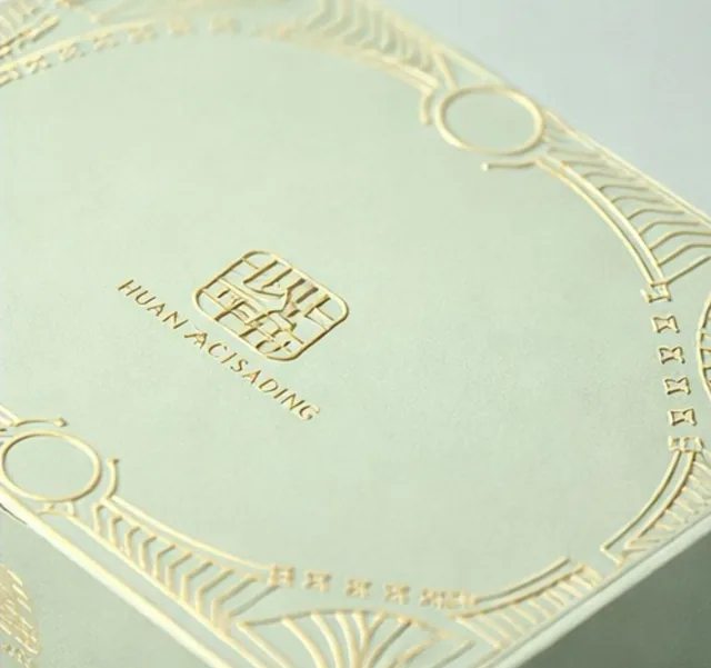 Macro of gold foil stamping on a pastel mint gift box