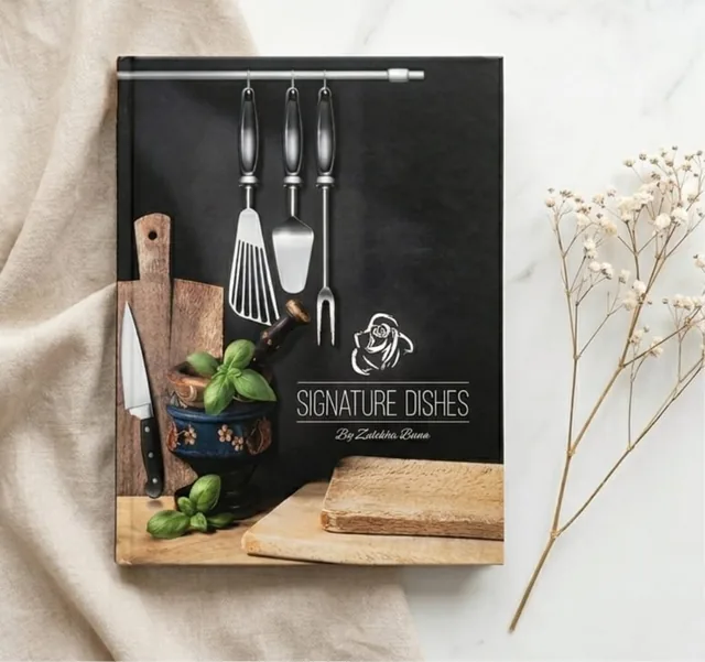 Black hardcover cookbook next to an open recipe spread